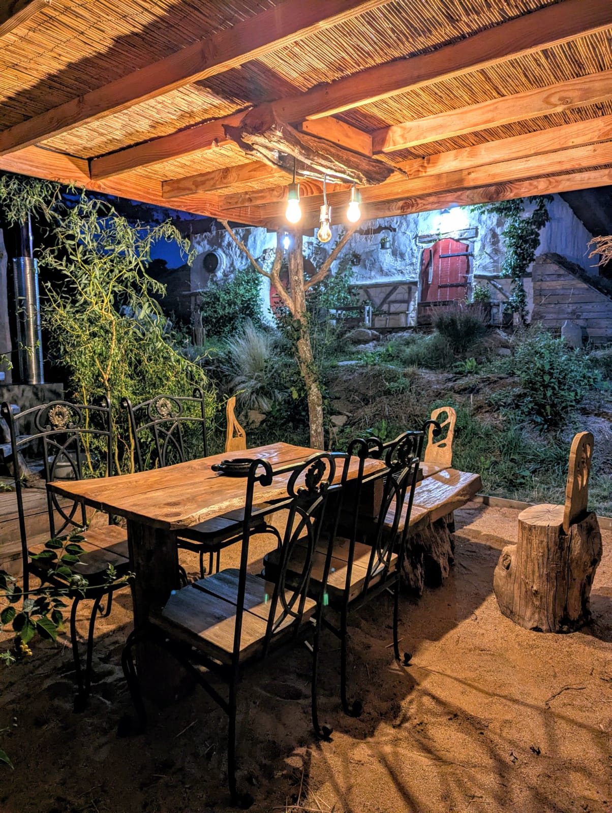 Vue extérieure de la Maison Sacquet - Maison de Hobbit semi-enterrée avec porte ronde en bois sculpté en Haute-Vienne